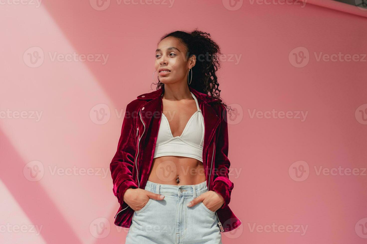 attractive black african american woman in stylish outfit on pink background photo