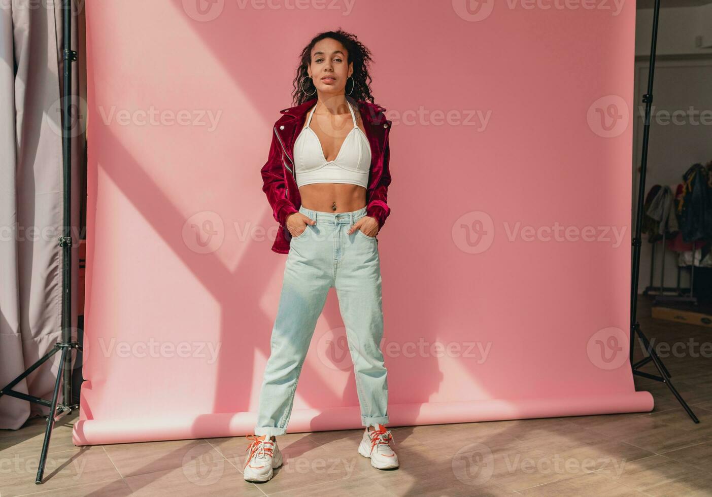 attractive black african american woman in stylish outfit on pink background photo