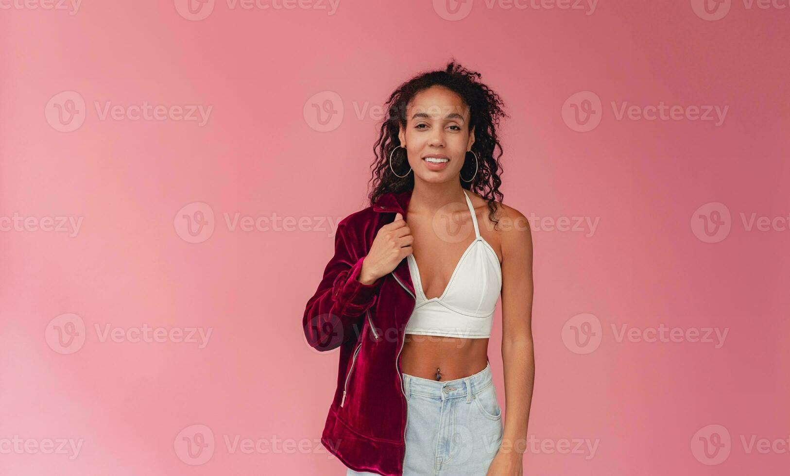 attractive black african american woman in stylish outfit on pink background photo