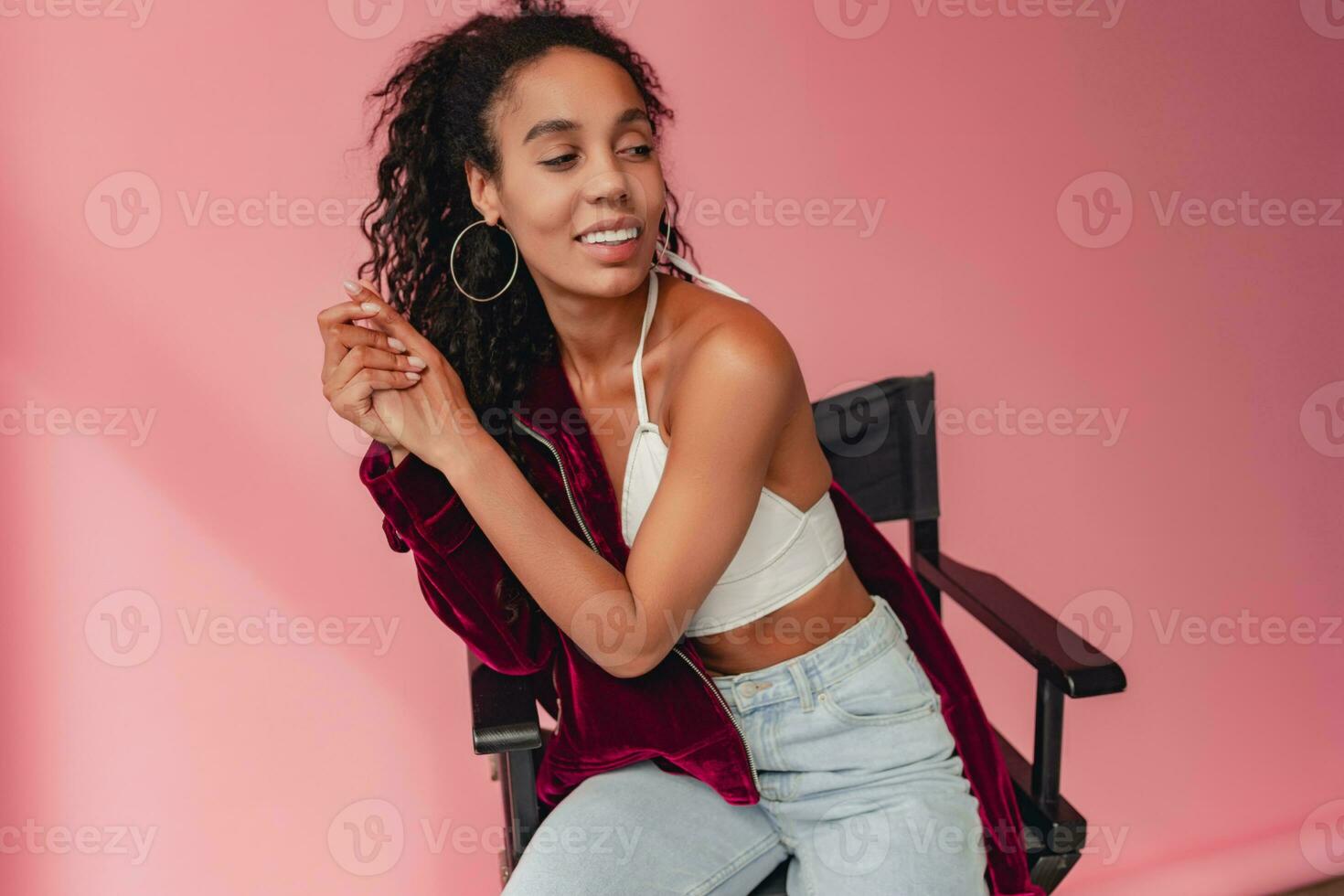 attractive black african american woman in stylish outfit on pink background photo