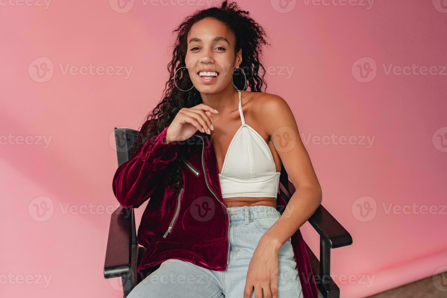 attractive black african american woman in stylish outfit on pink background photo