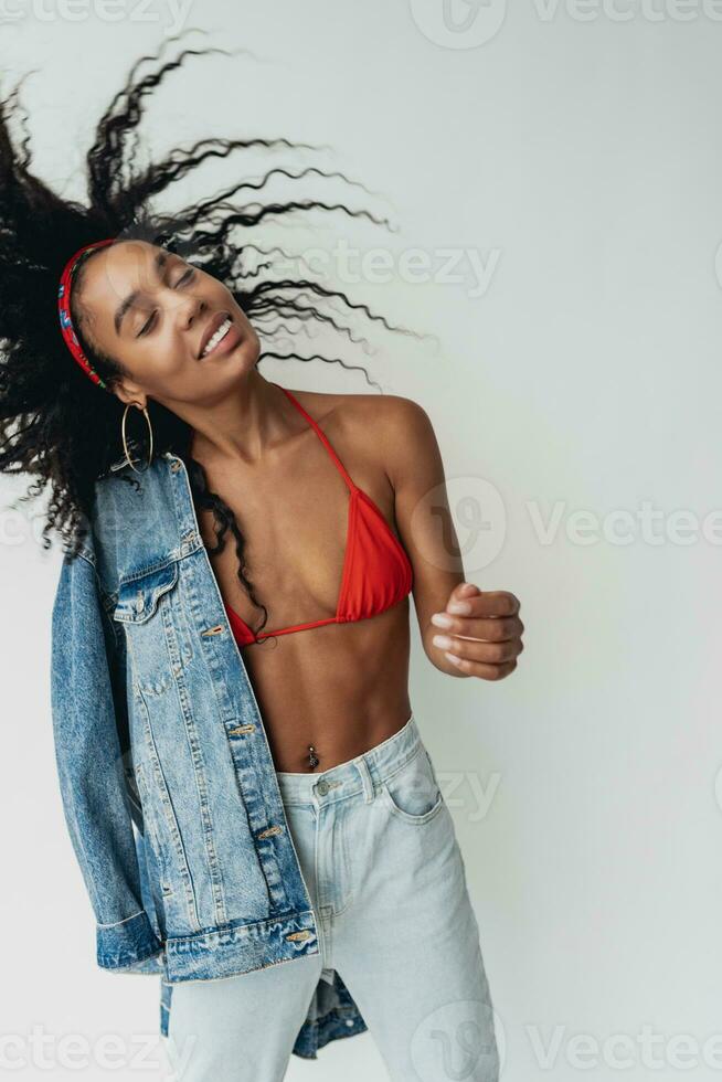 attractive black african american woman posing in stylish hipster outfit on white background photo
