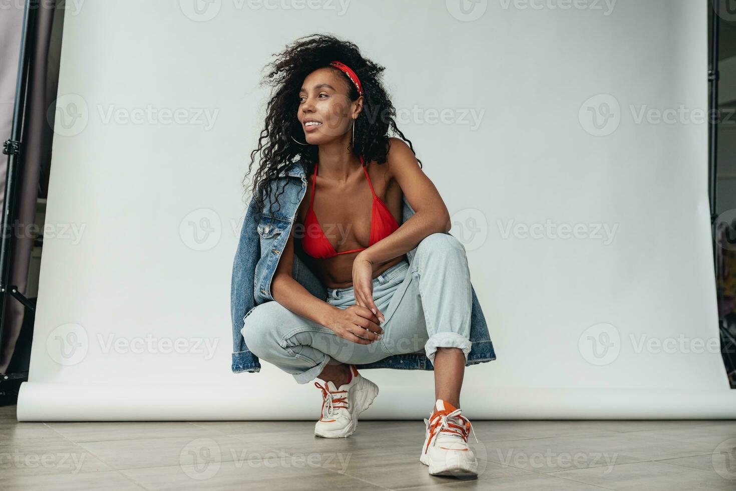 attractive black african american woman posing in stylish hipster outfit on white background photo