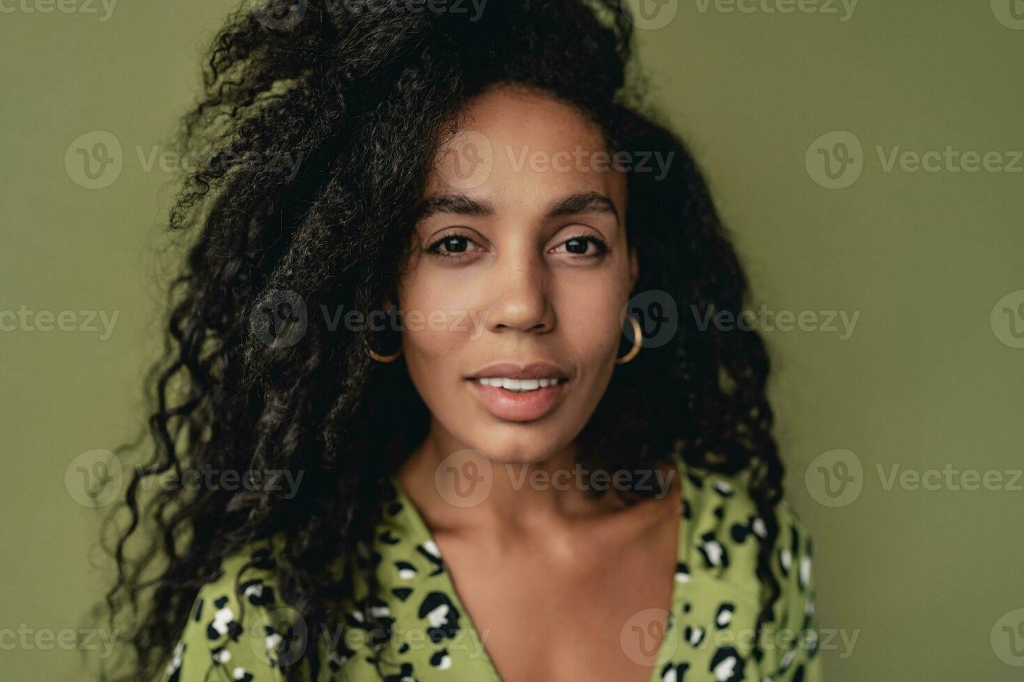 attractive black african american woman posing in stylish green dress isolated on green background photo