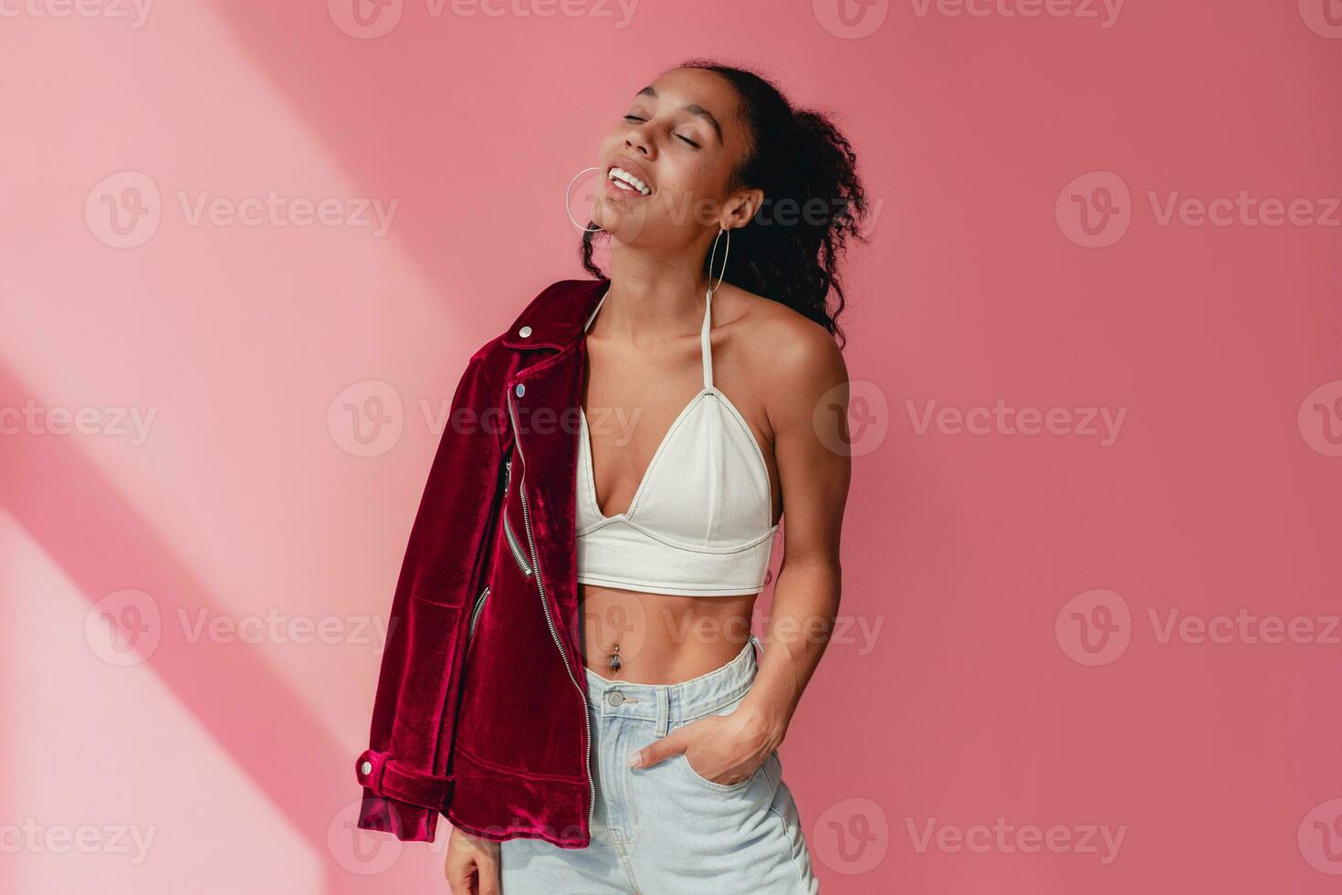 attractive black african american woman in stylish outfit on pink background photo