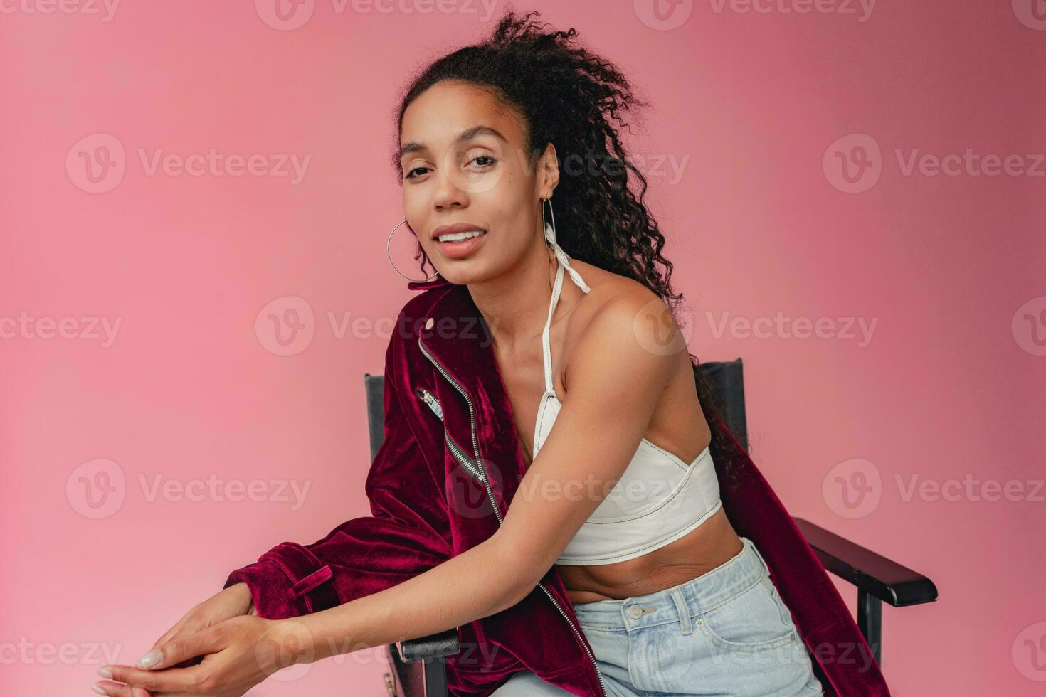 attractive black african american woman in stylish outfit on pink background photo