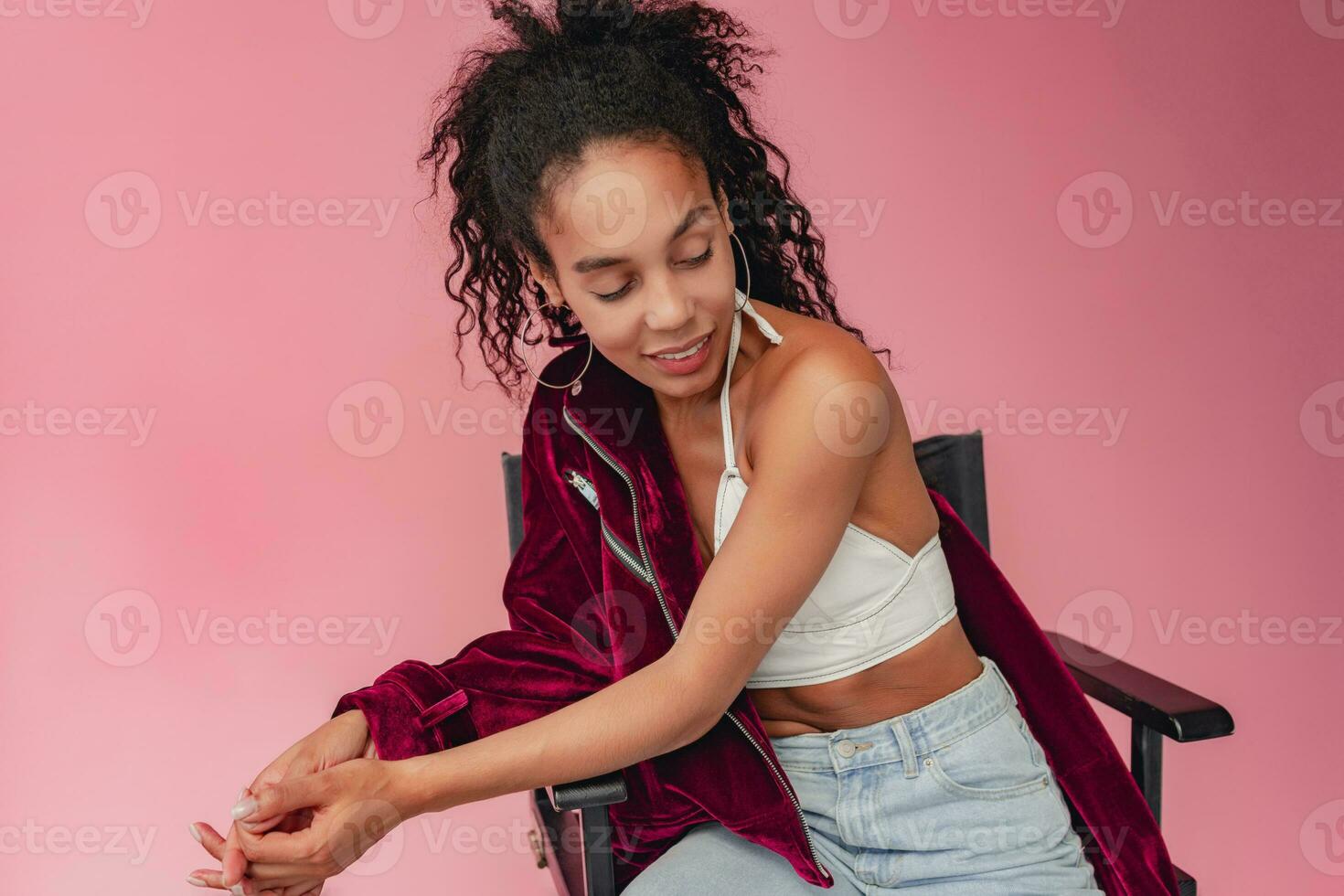 attractive black african american woman in stylish outfit on pink background photo