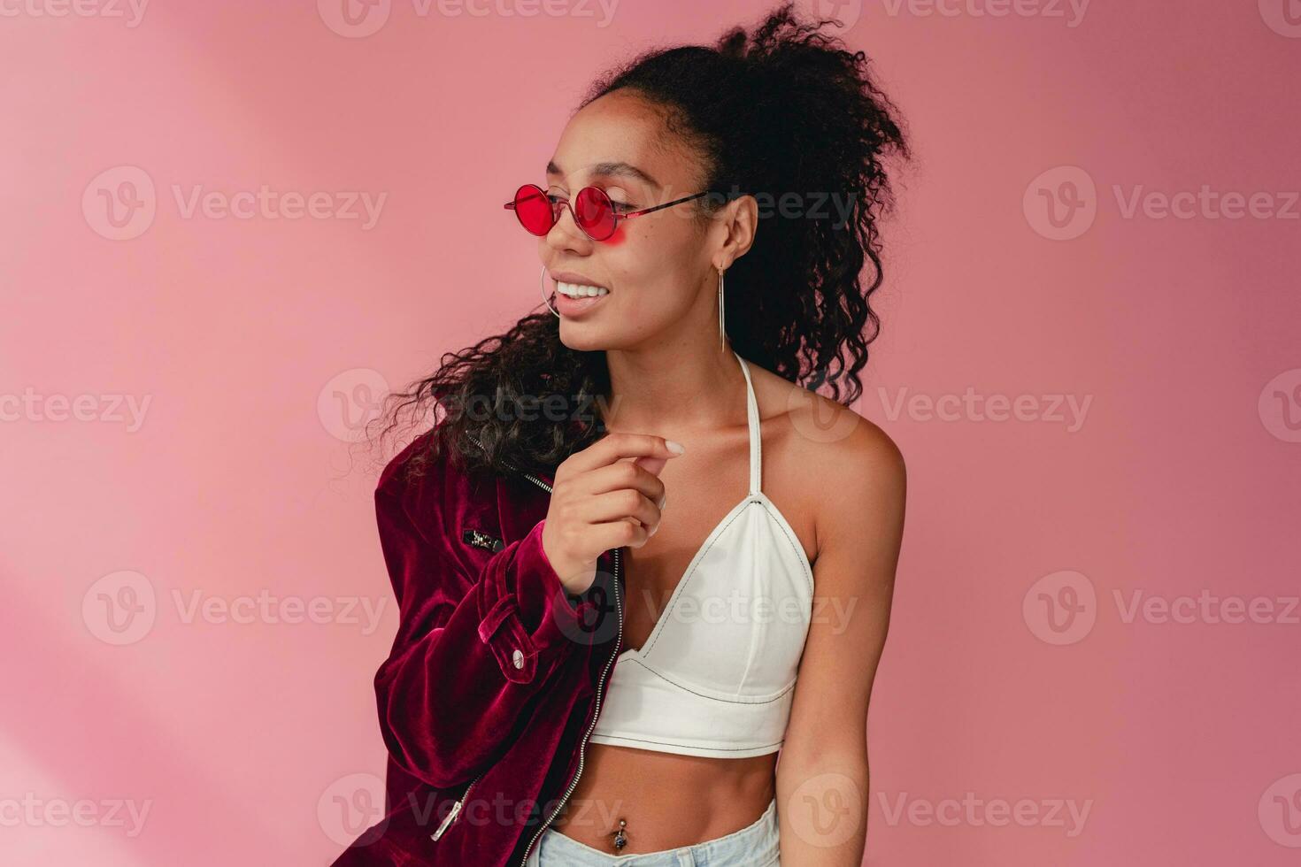 attractive black african american woman in stylish outfit on pink background photo