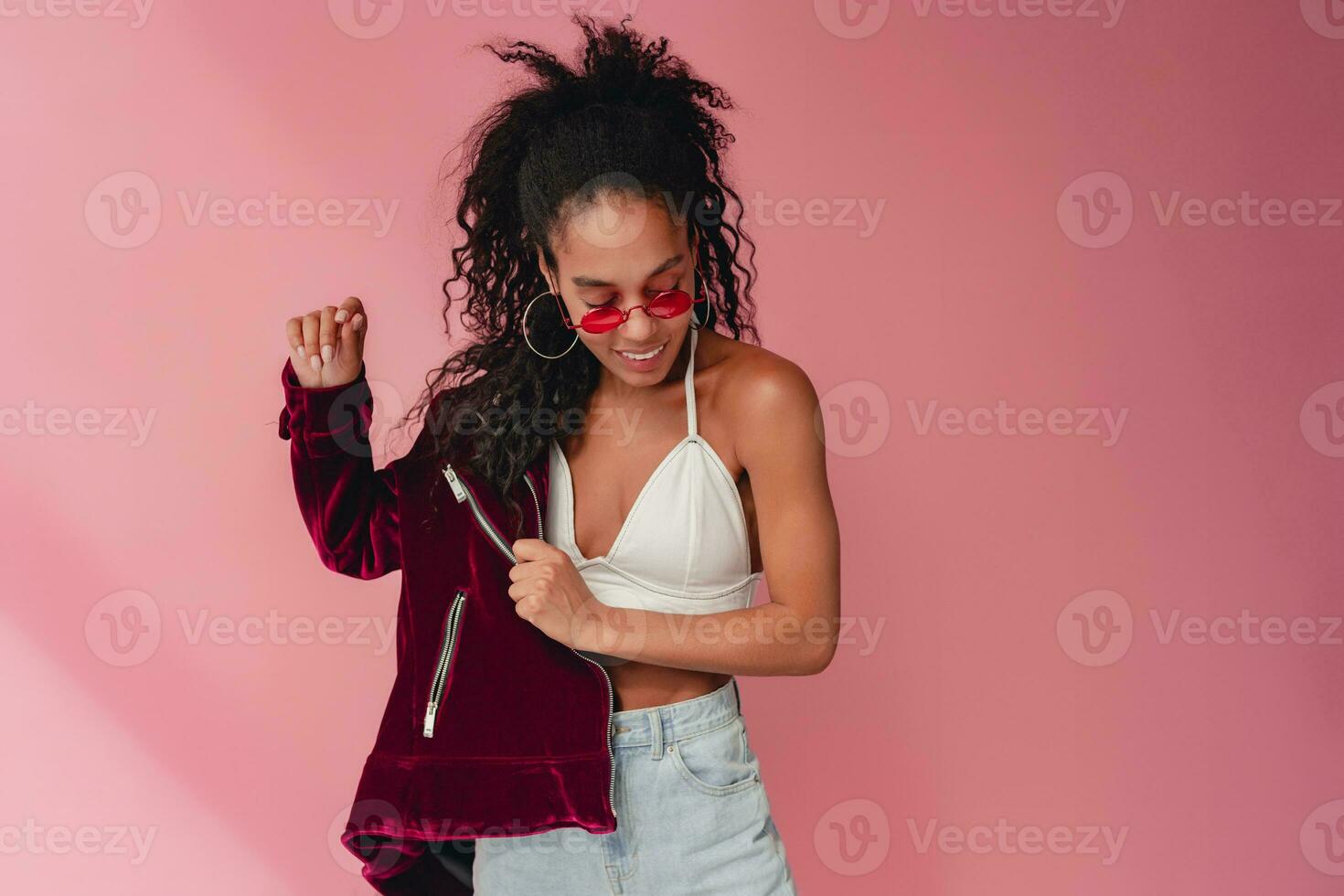 attractive black african american woman in stylish outfit on pink background photo