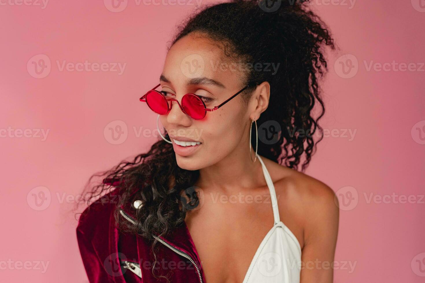 attractive black african american woman in stylish outfit on pink background photo