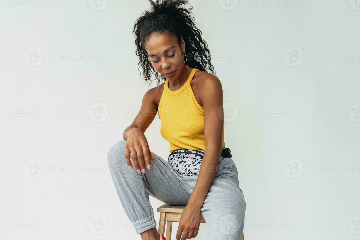 attractive black african american woman posing in stylish hipster outfit on white background photo