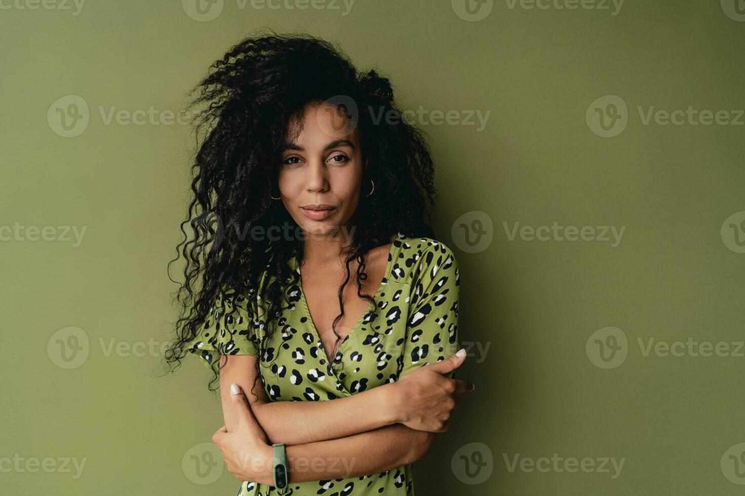 attractive black african american woman posing in stylish green dress isolated on green background photo