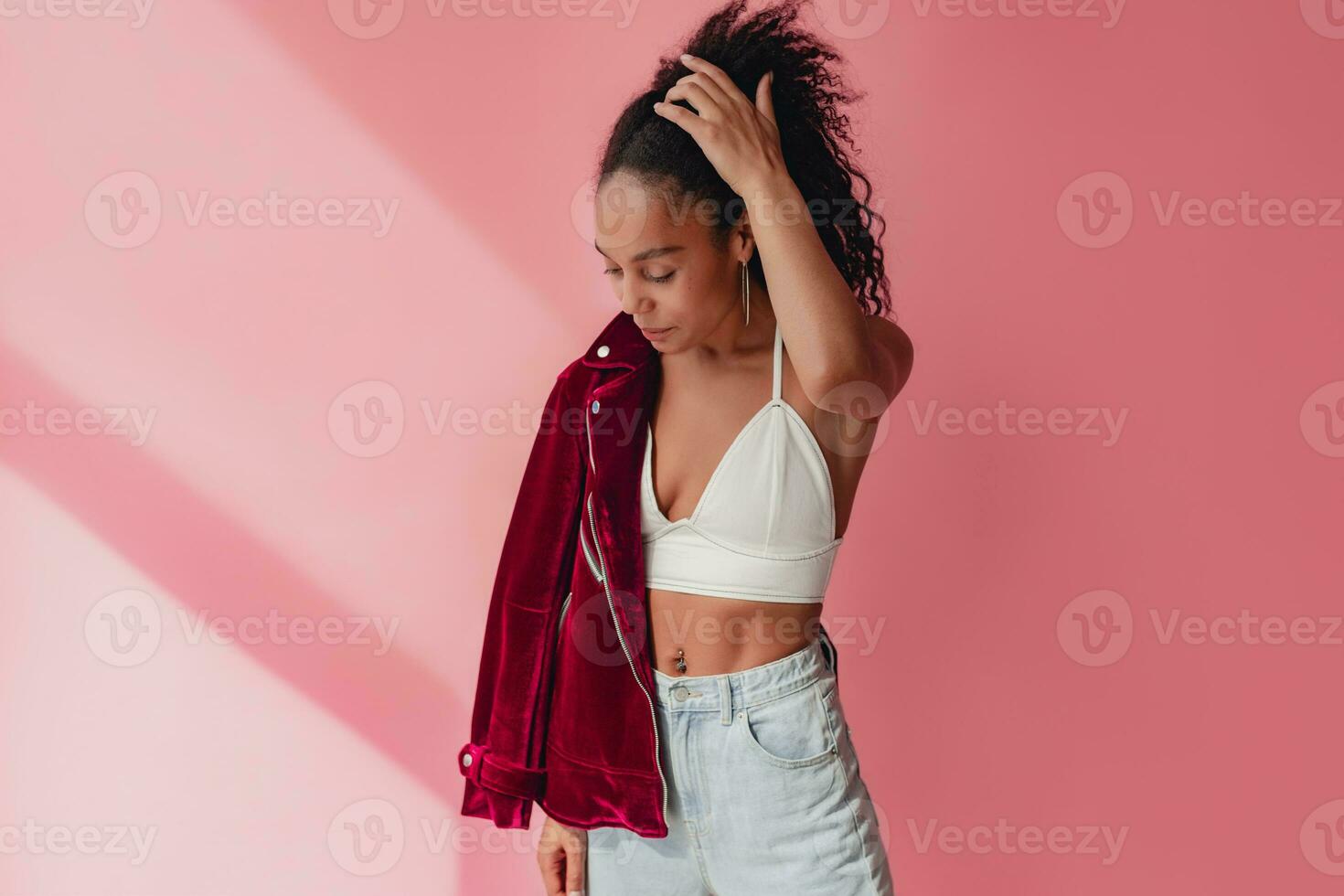 attractive black african american woman in stylish outfit on pink background photo