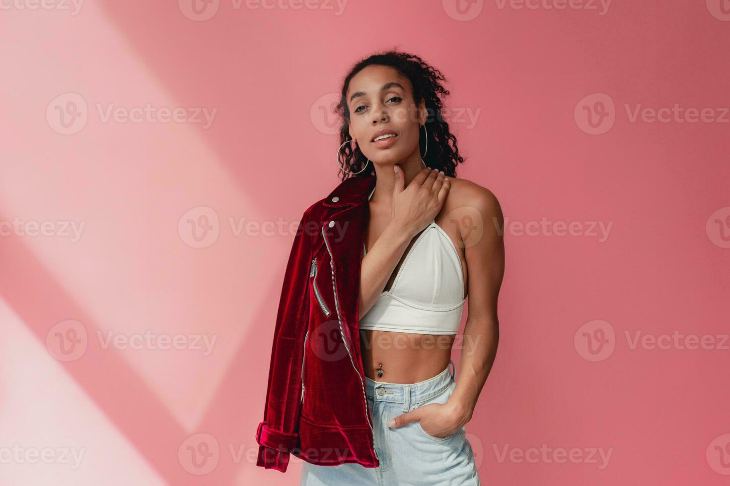 attractive black african american woman in stylish outfit on pink background photo