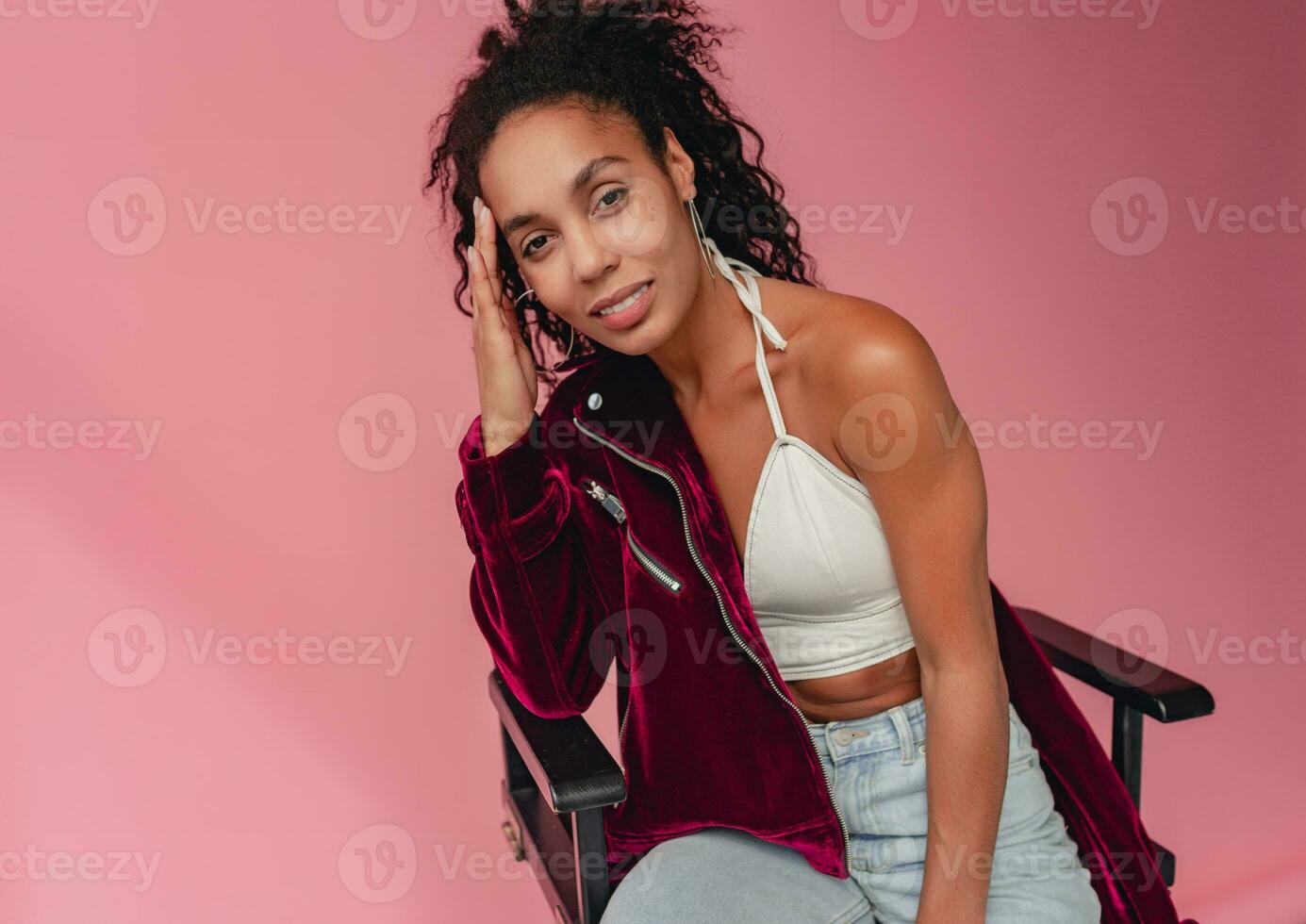 attractive black african american woman in stylish outfit on pink background photo