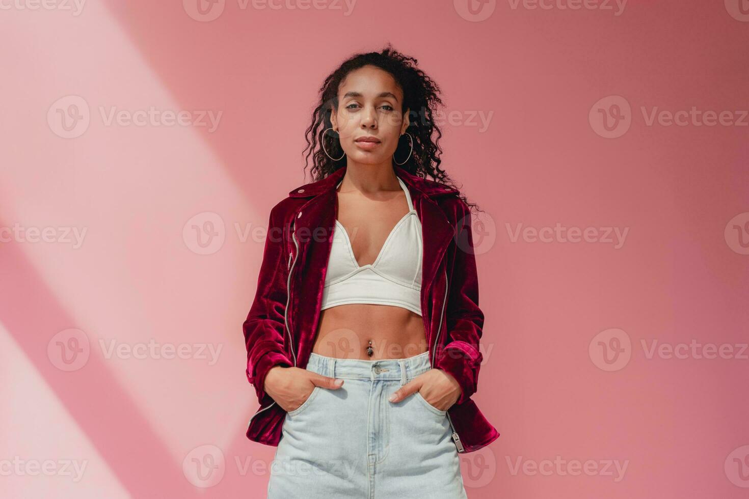 attractive black african american woman in stylish outfit on pink background photo