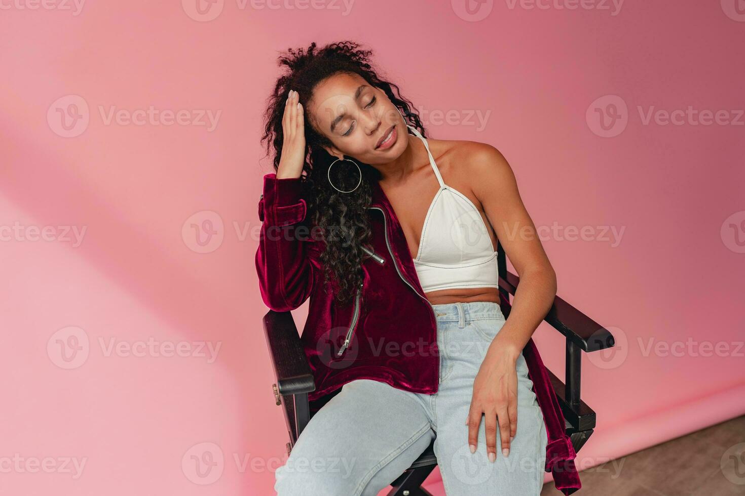 attractive black african american woman in stylish outfit on pink background photo