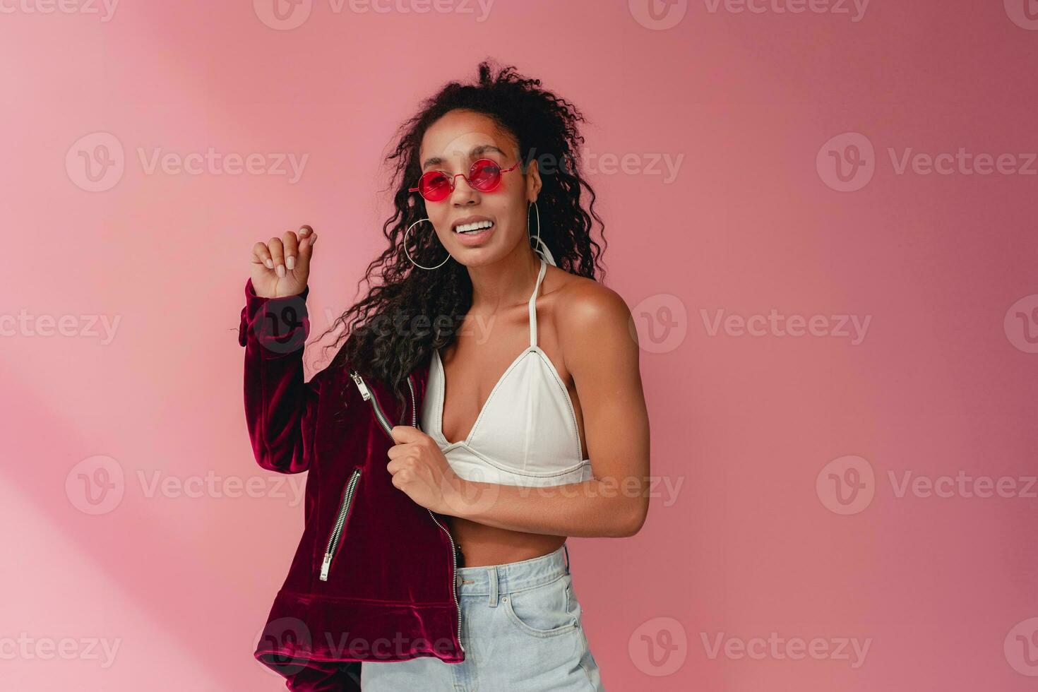 attractive black african american woman in stylish outfit on pink background photo