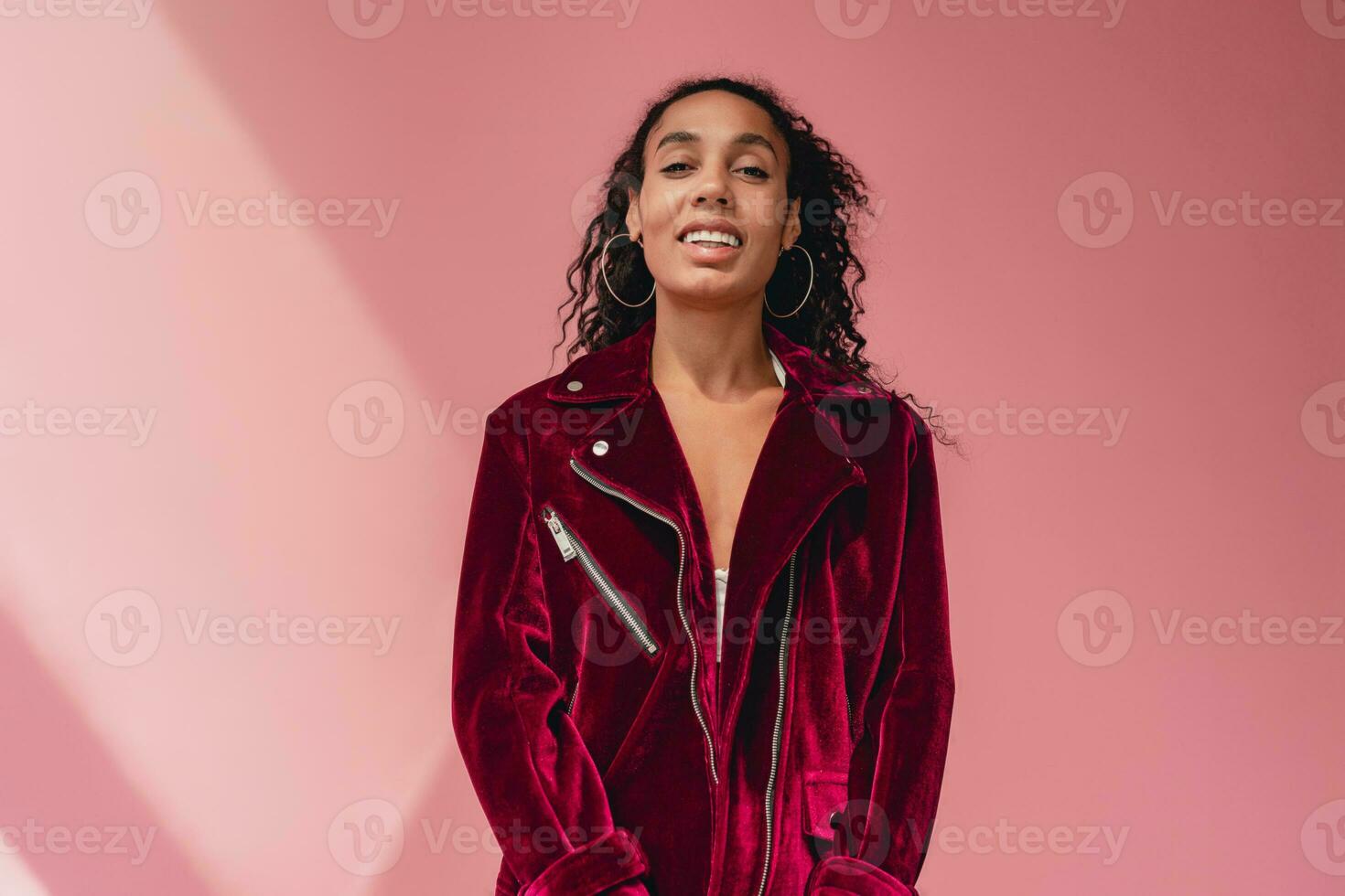 attractive black african american woman in stylish outfit on pink background photo