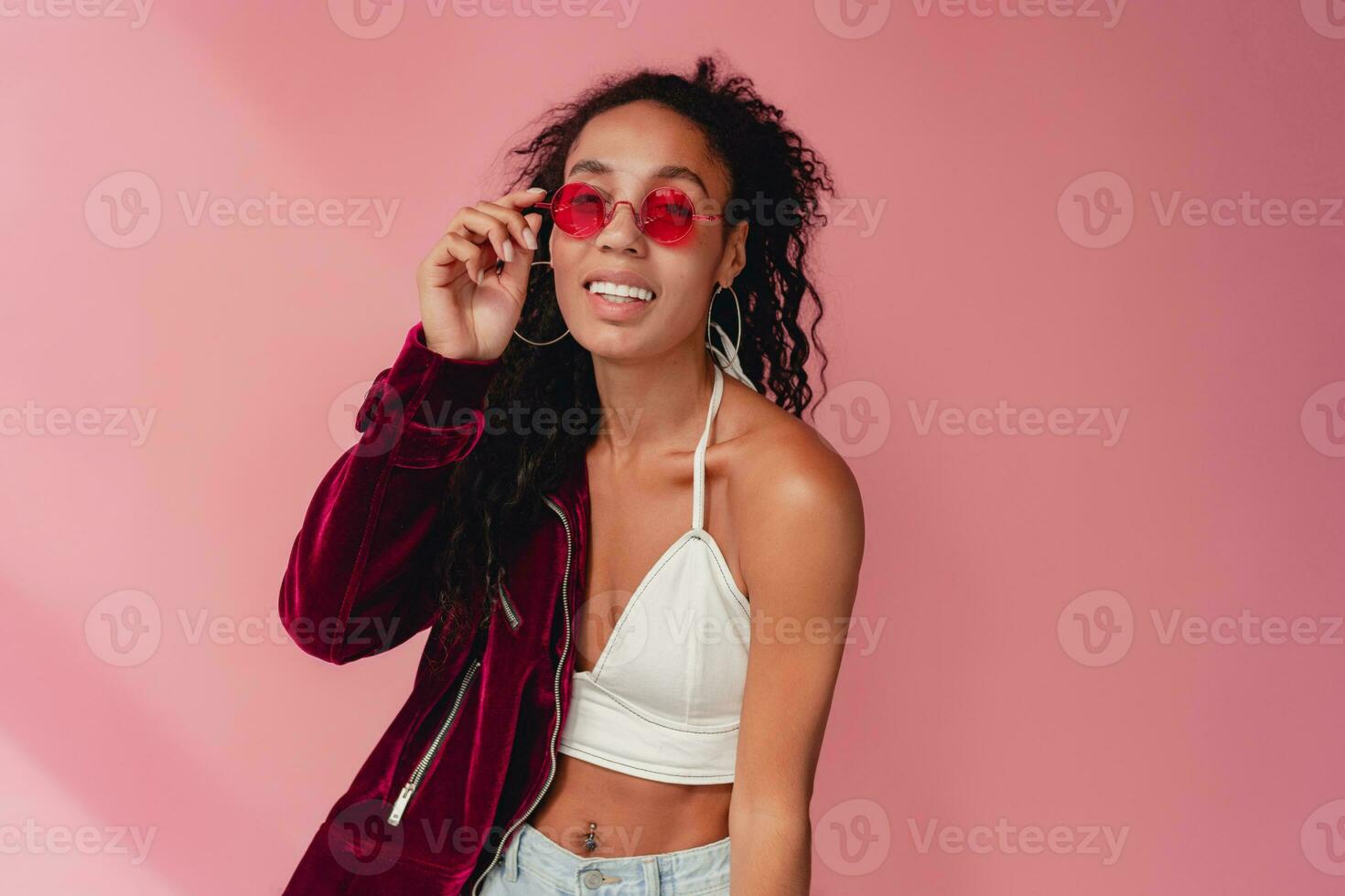 attractive black african american woman in stylish outfit on pink background photo