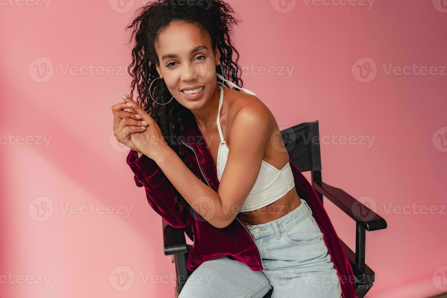 attractive black african american woman in stylish outfit on pink background photo