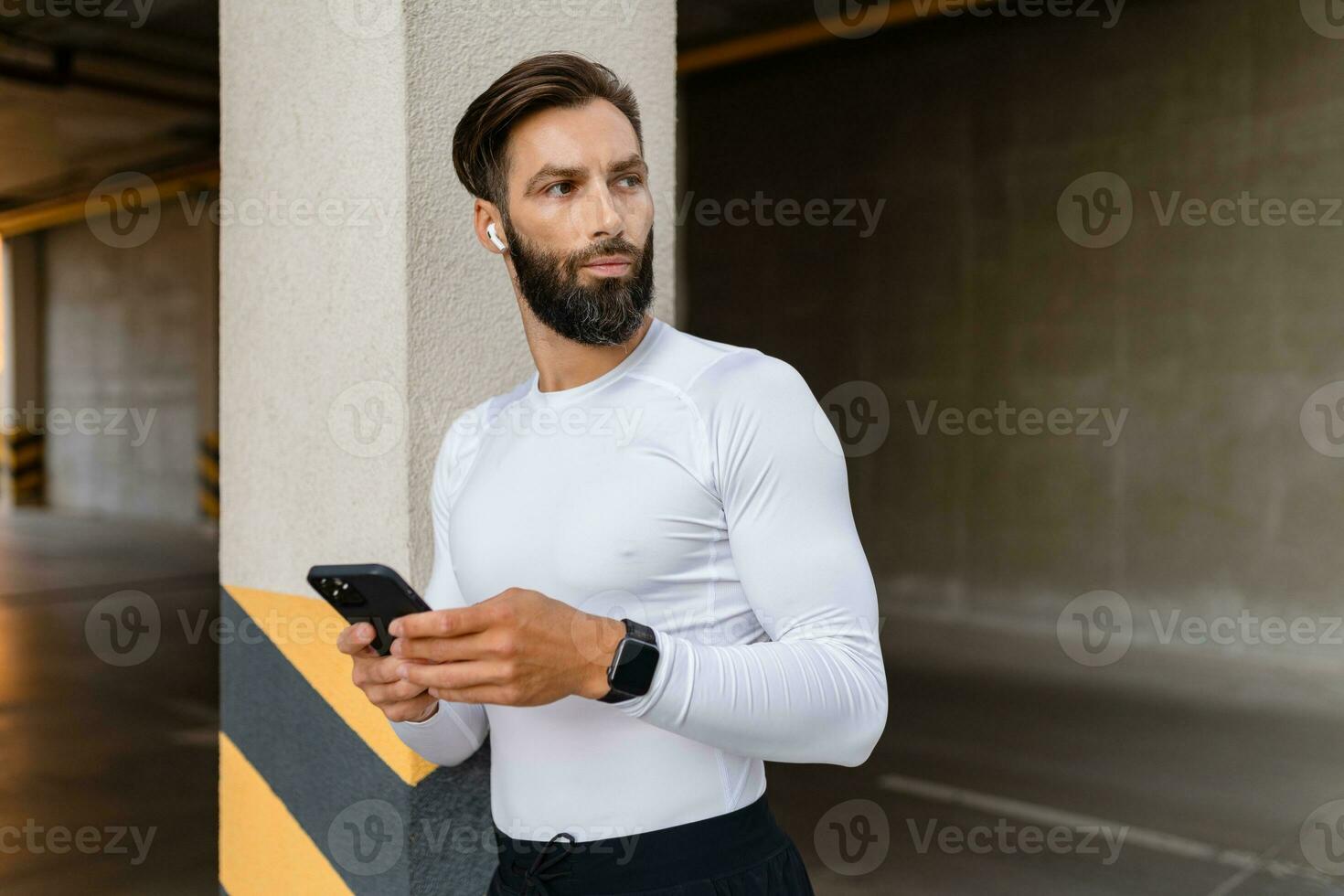 athletic strong hansome man on morning fitness workout exercise in sportswear using smartphone photo