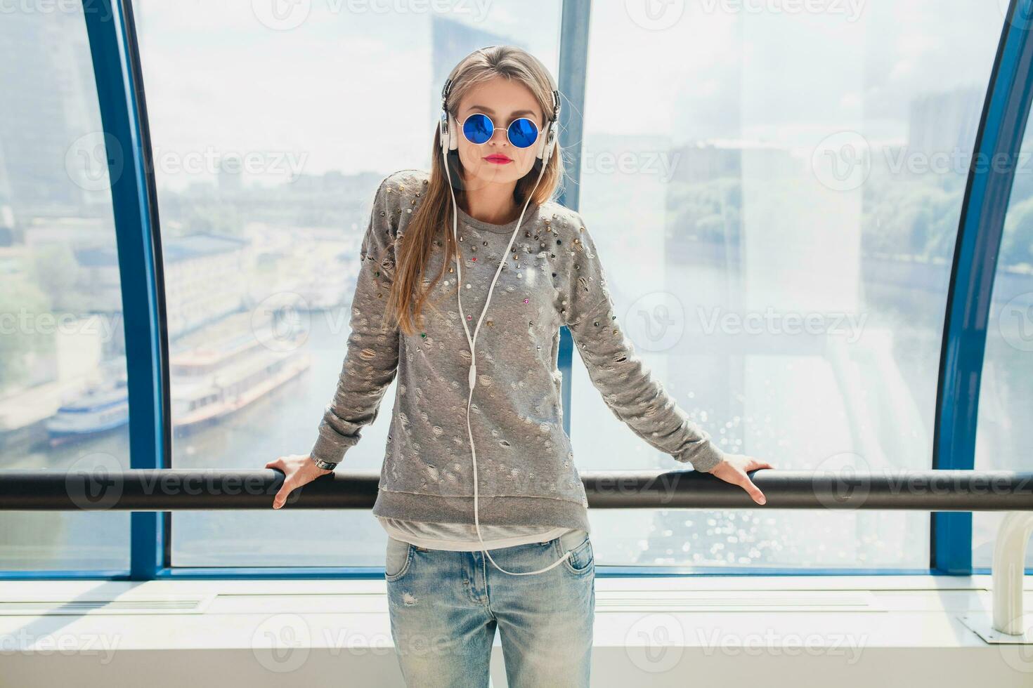 young hipster woman in casual outfit having fun listening to music photo