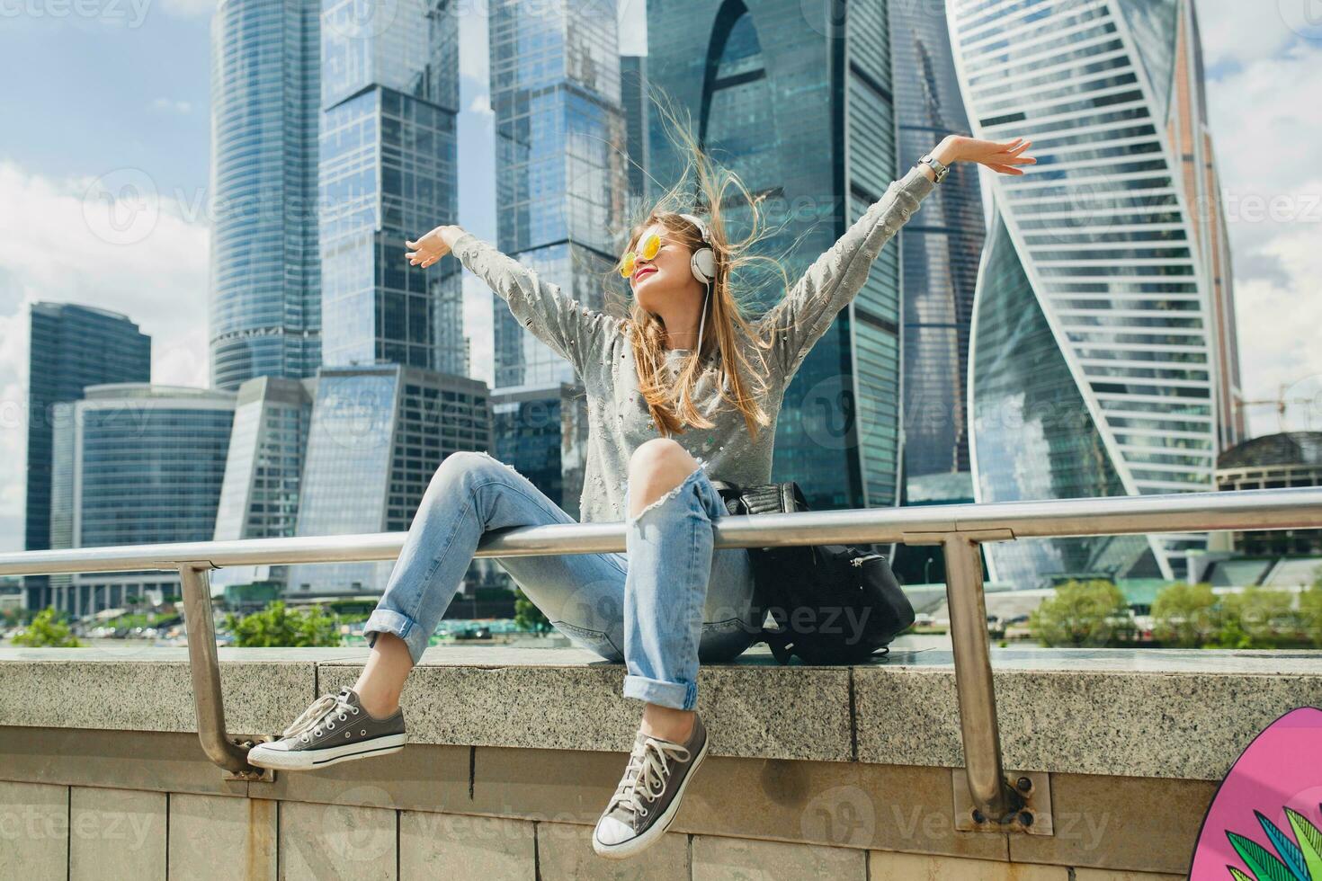 young hipster woman in casual outfit having fun listening to music photo