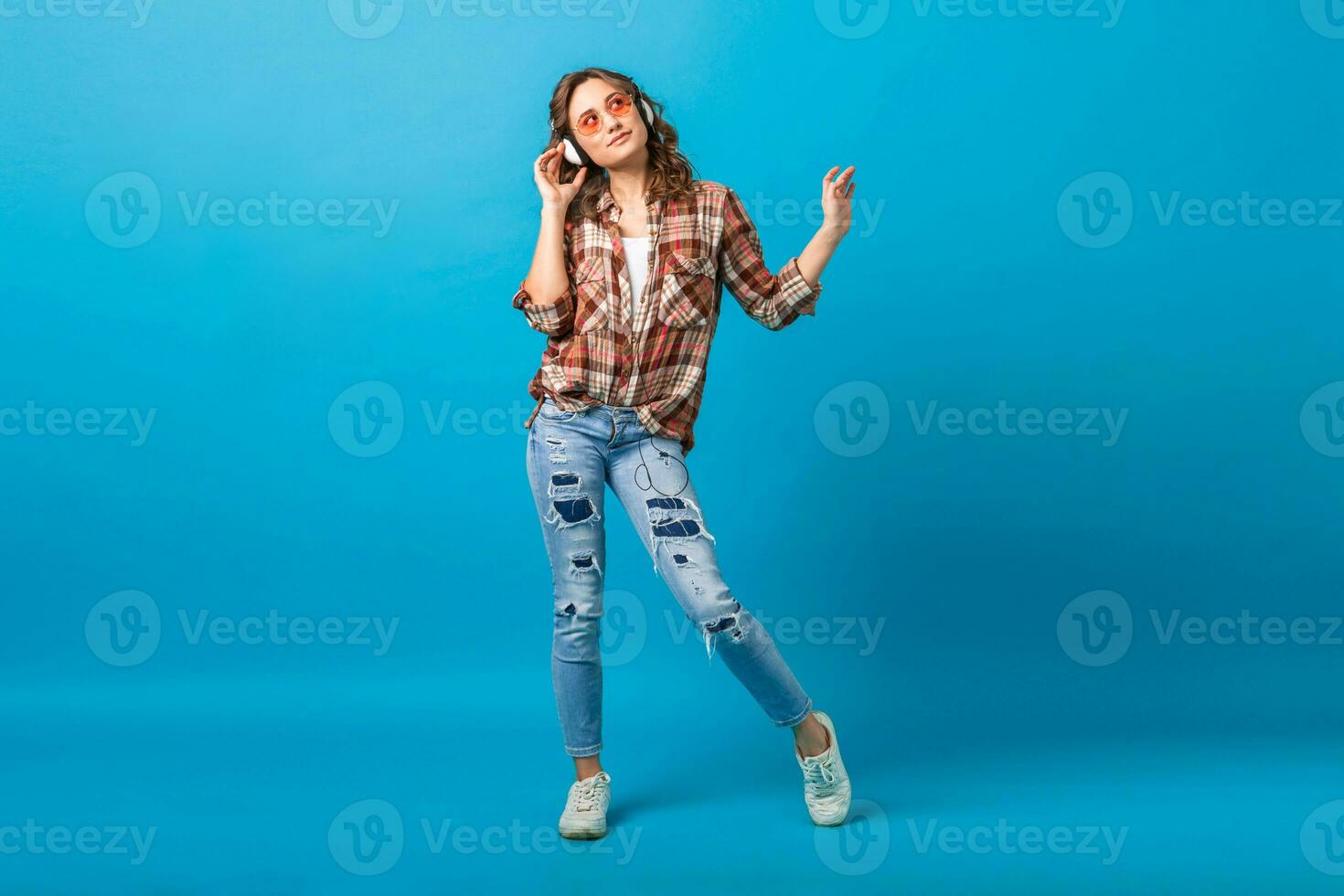 atractivo mujer en alegre salido estado animico escuchando a música en auriculares foto