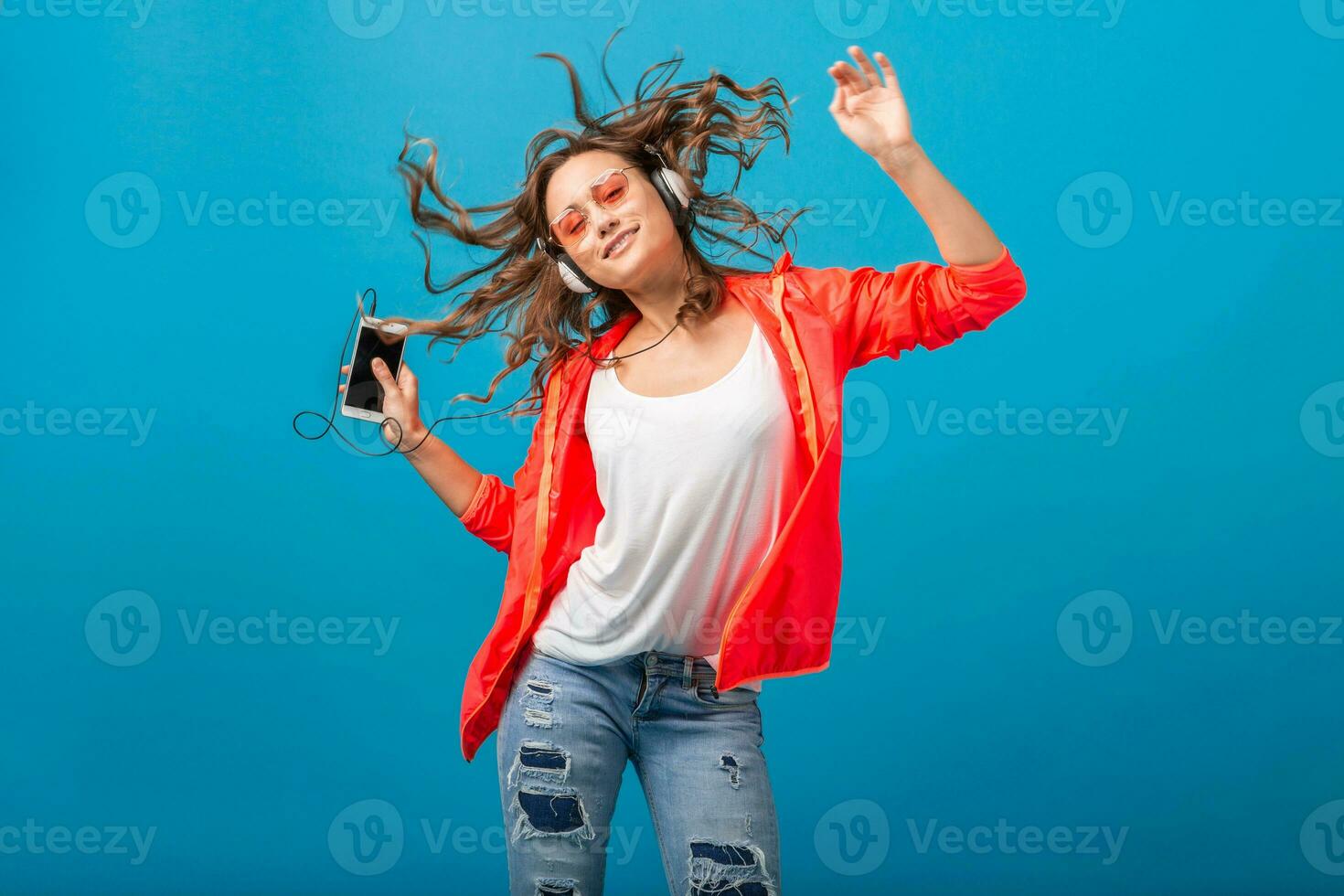 attractive woman in cheerful exited mood listening to music in headphones photo