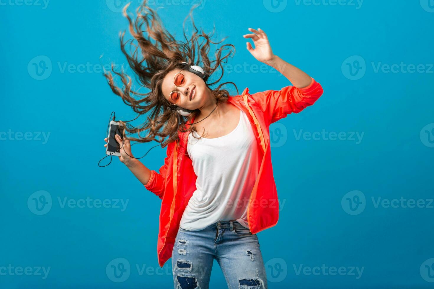 atractivo mujer en alegre salido estado animico escuchando a música en auriculares foto