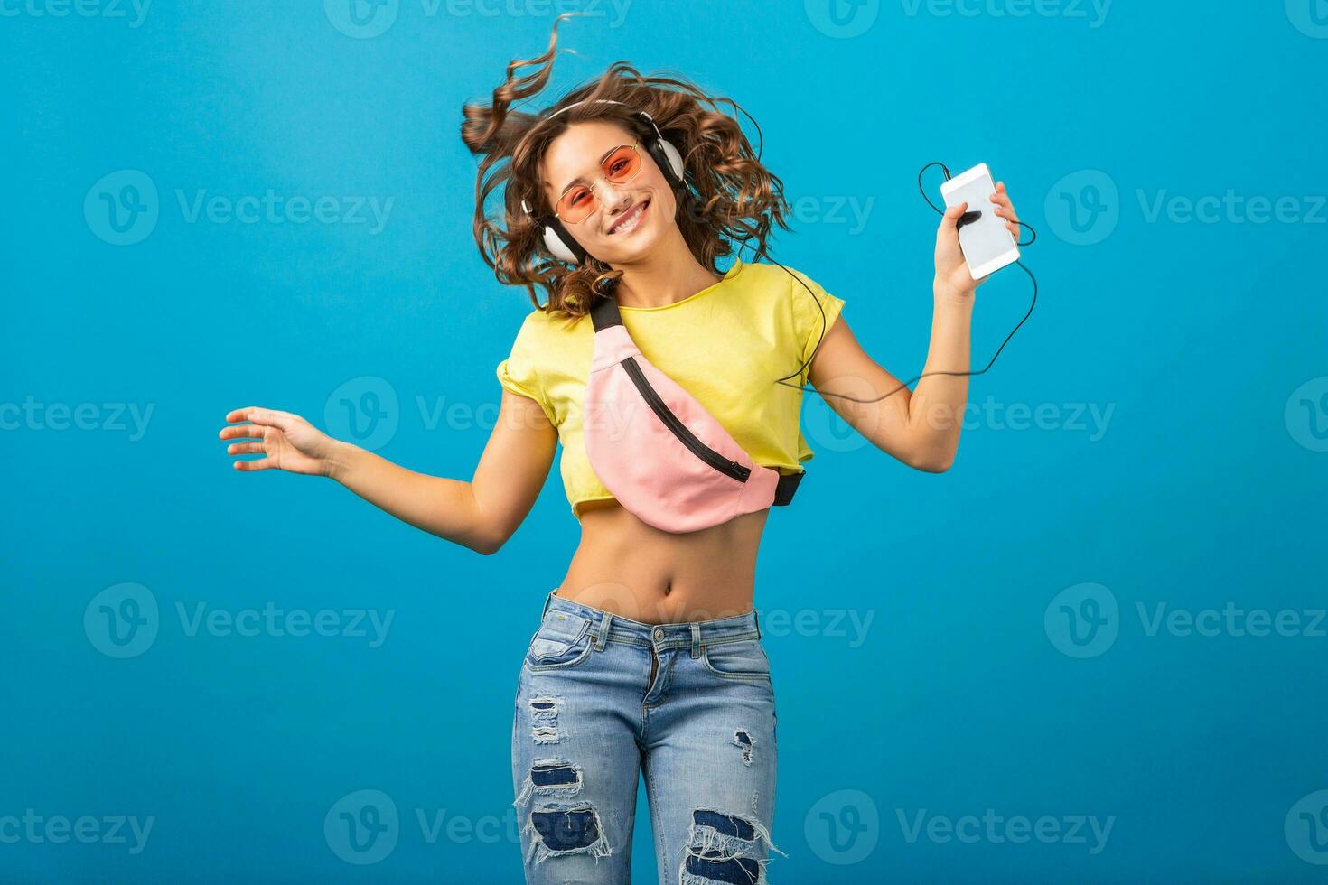 attractive woman in cheerful exited mood listening to music in headphones photo