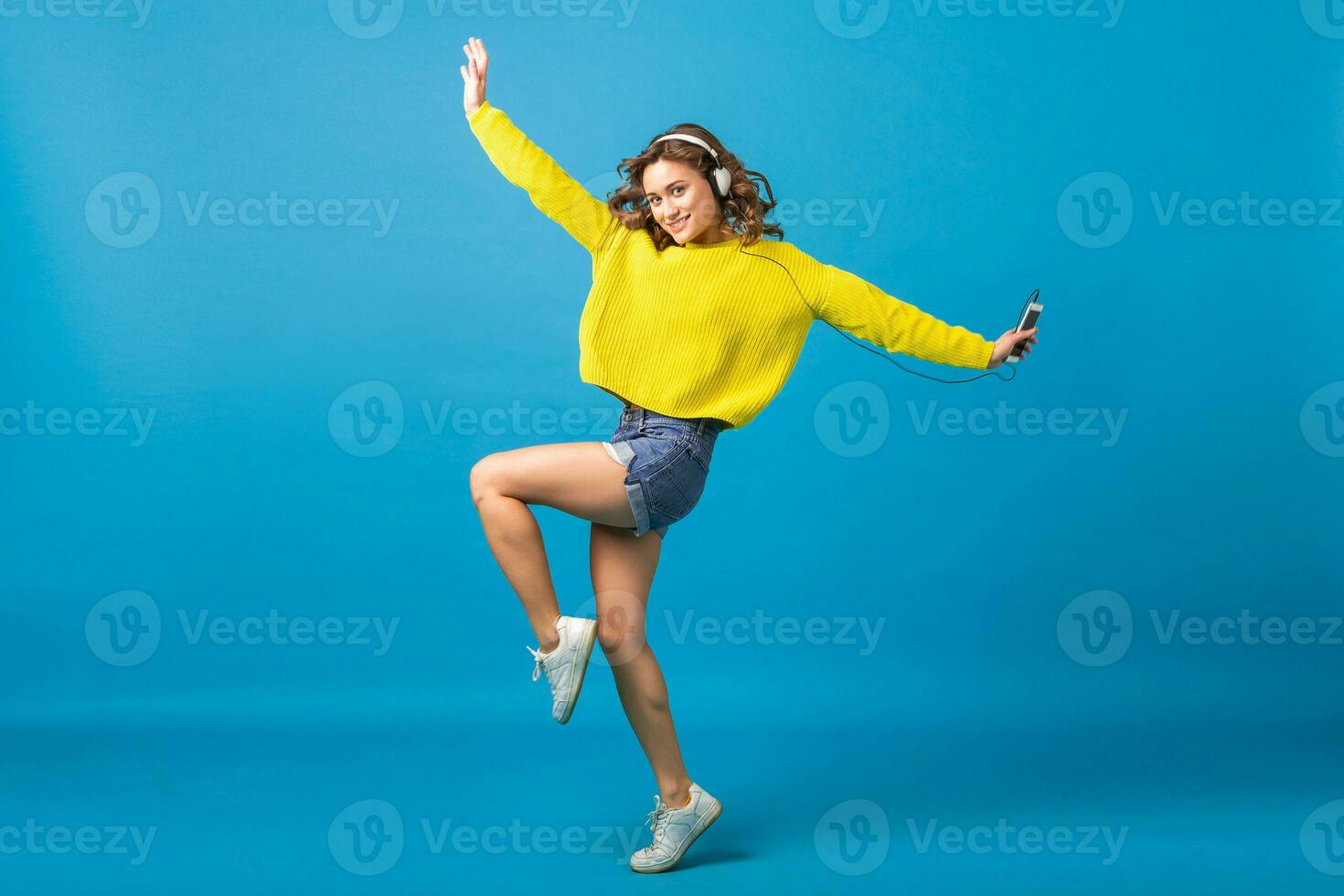 atractivo mujer en alegre salido estado animico escuchando a música en auriculares foto