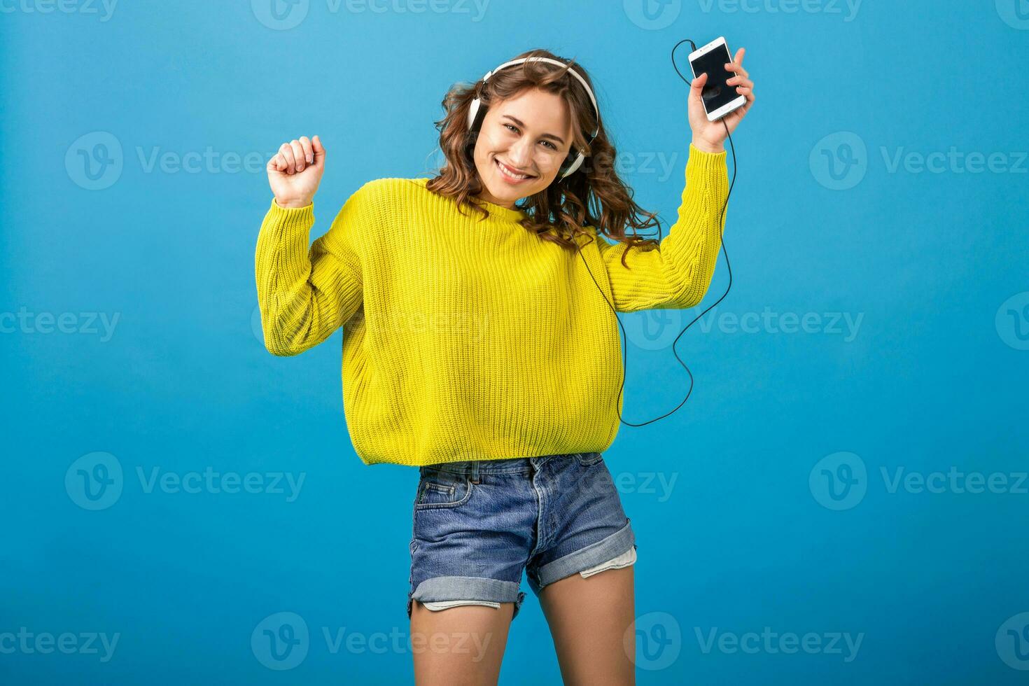 attractive woman in cheerful exited mood listening to music in headphones photo