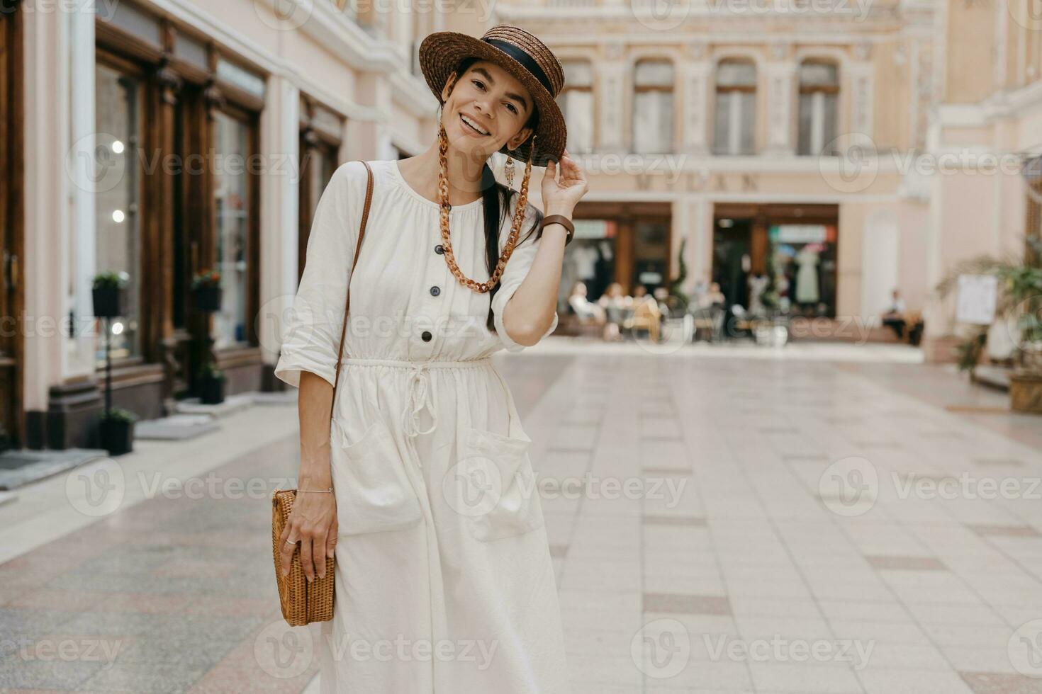 attractive woman walking in shopping street in Italy on vacation dressed in white summer fashion dress photo