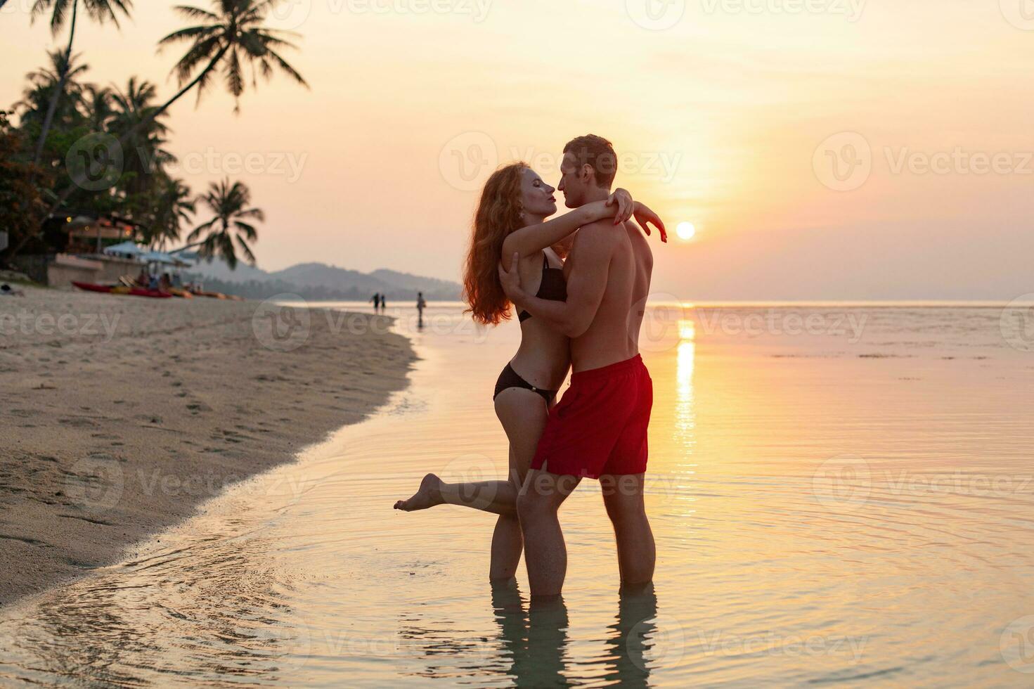 young sexy romantic couple in love happy on summer beach together having fun wearing swim suits photo