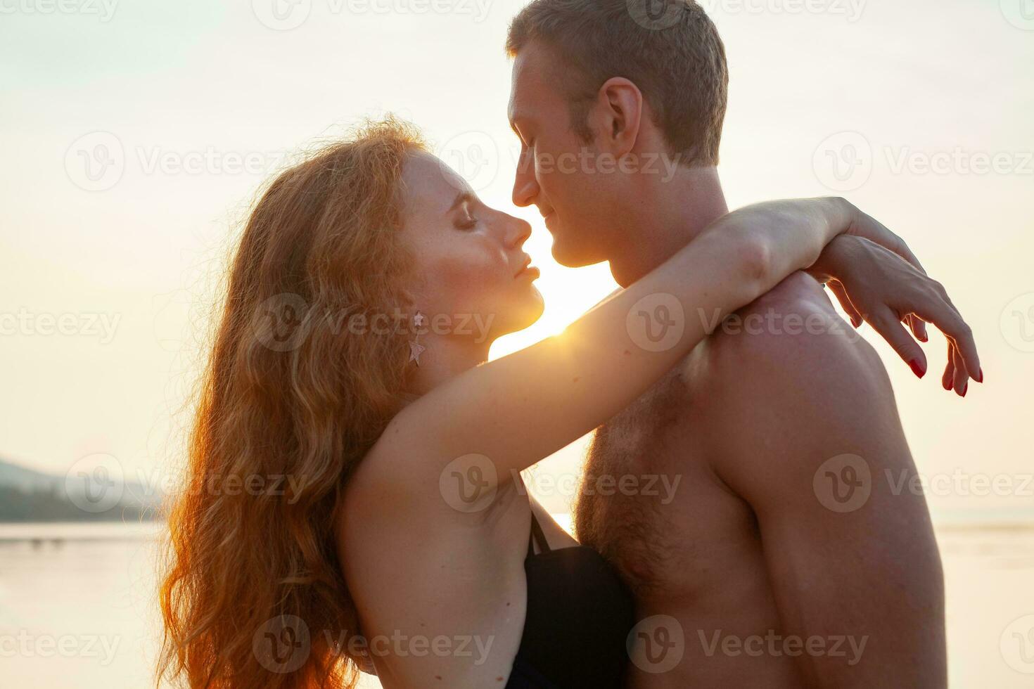 young sexy romantic couple in love happy on summer beach together having fun wearing swim suits photo