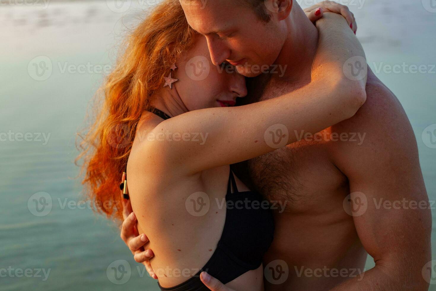 young sexy romantic couple in love happy on summer beach together having fun wearing swim suits photo