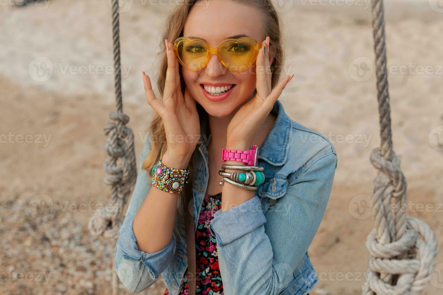 stylish woman in summer dress vacation on beach in colorful yellow sunglasess smiling happy photo