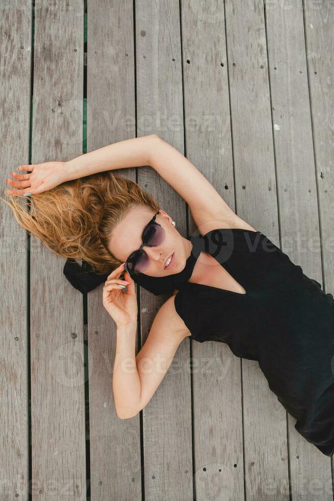 luxury sexy attractive woman dressed in romantic black dress lying on floor photo
