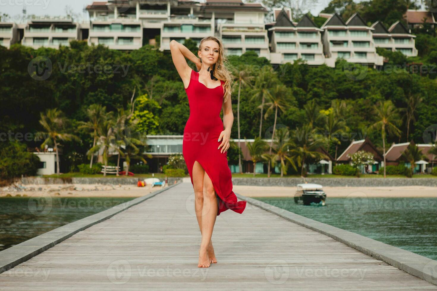 joven hermosa atractivo mujer en pie solo en muelle rojo largo vestir foto