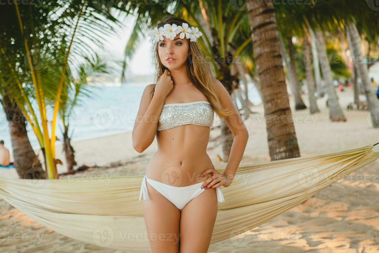 joven sexy mujer en blanco bikini traje de baño en tropical playa foto