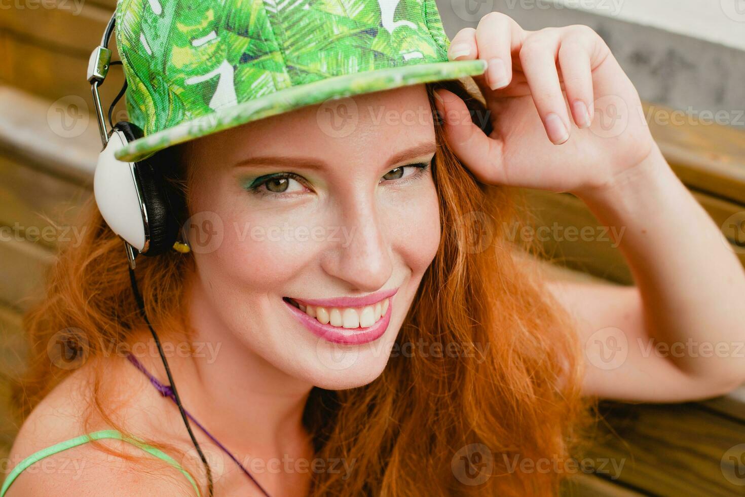 young stylish hipster ginger woman, sitting on bench, listening music photo