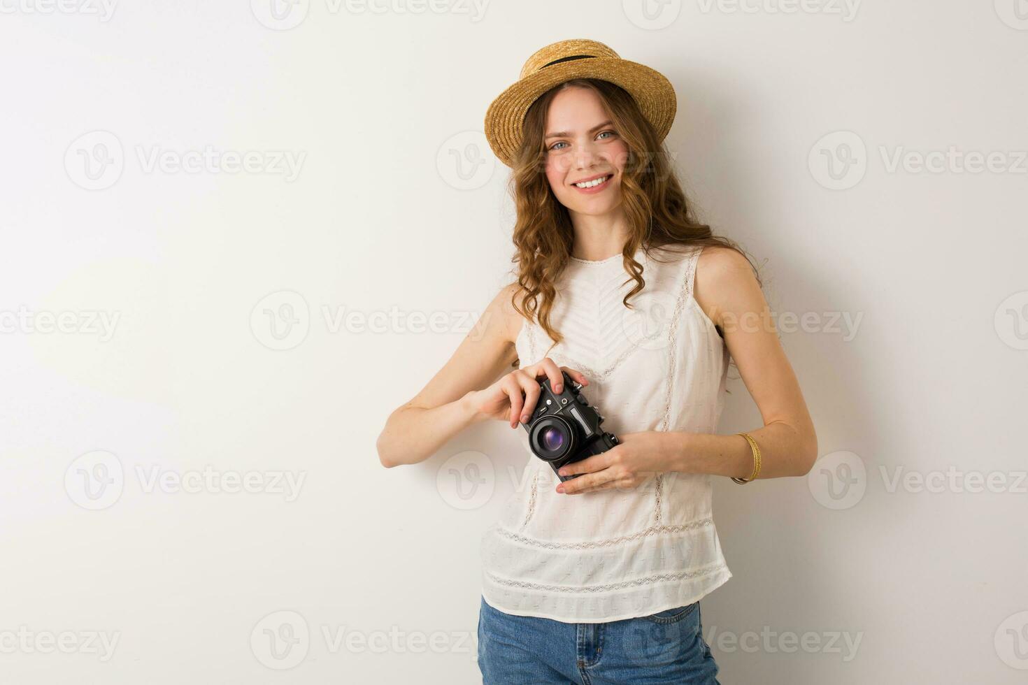 young pretty woman in summer vacation style outfit holding vintage photo camera