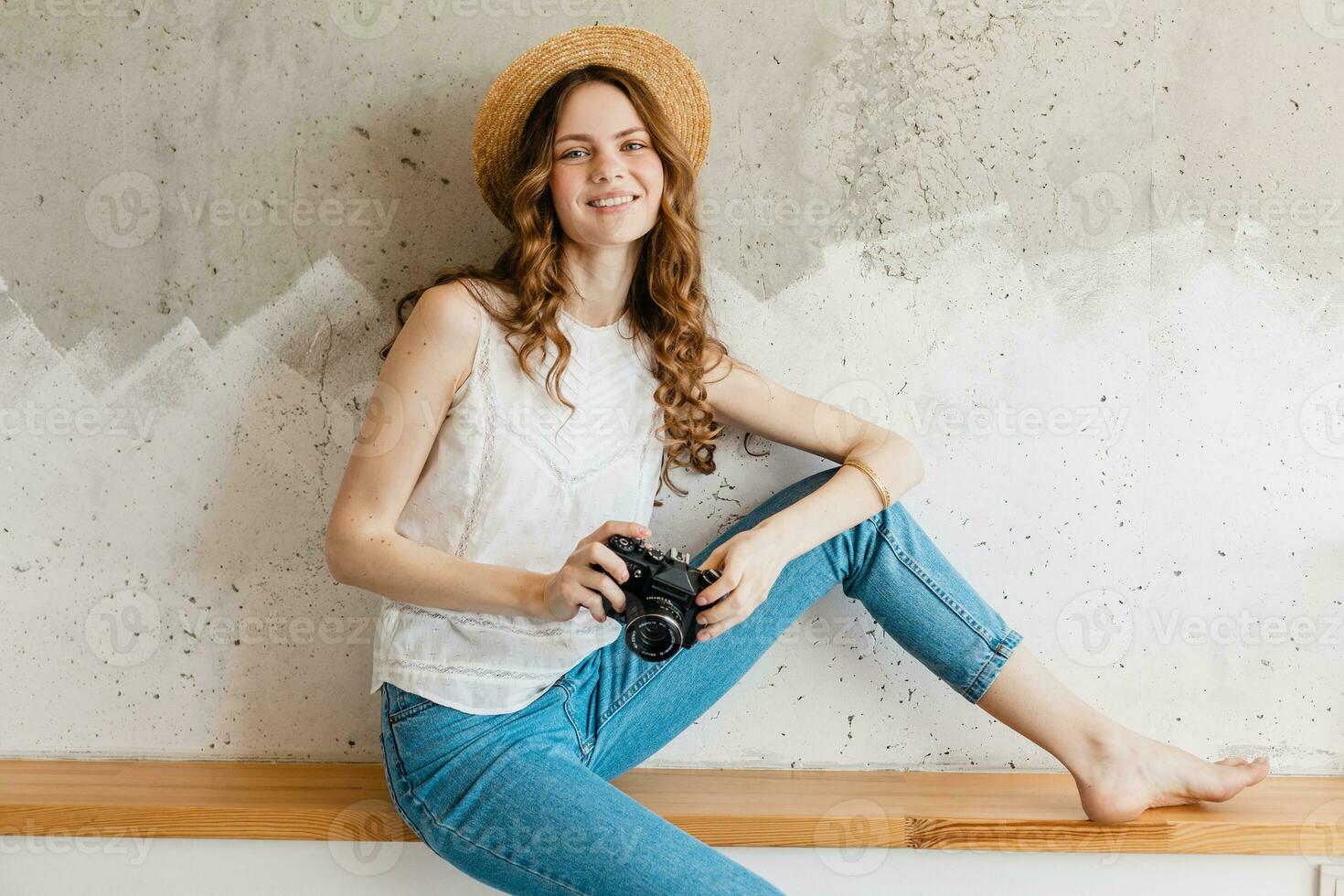 young pretty woman in summer vacation style outfit holding vintage photo camera