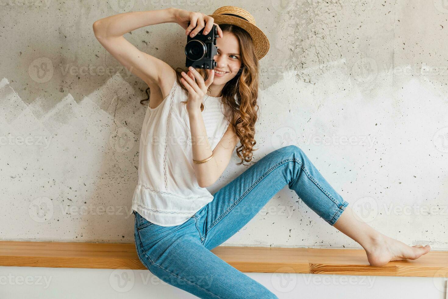 young pretty woman in summer vacation style outfit holding vintage photo camera