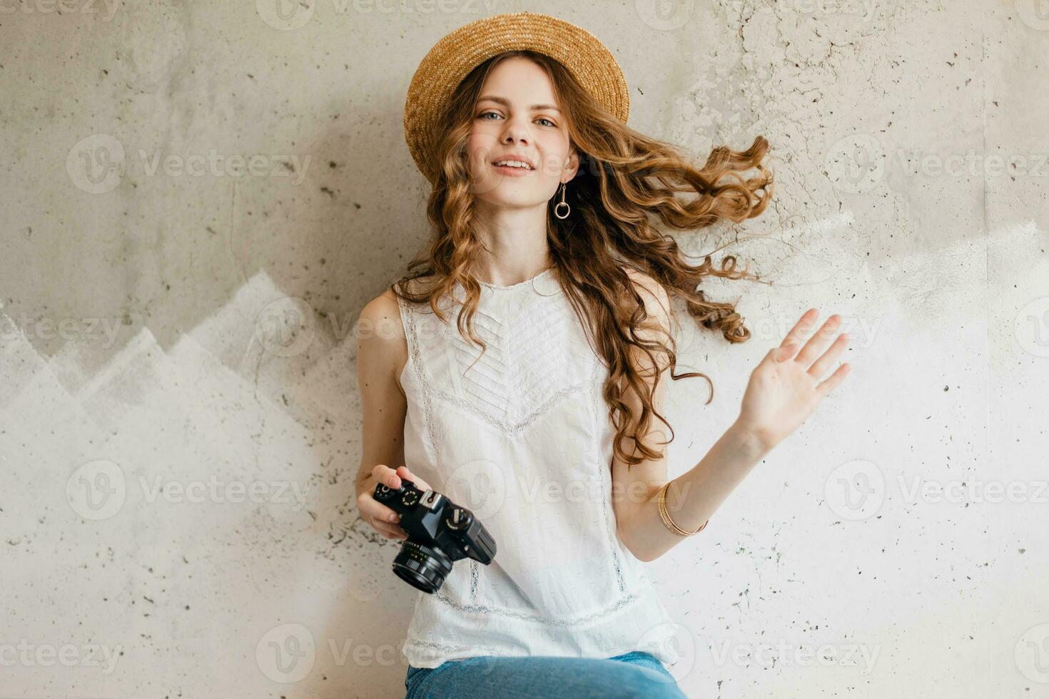 joven bonito sonriente contento mujer en Paja sombrero participación Clásico foto cámara, largo Rizado pelo