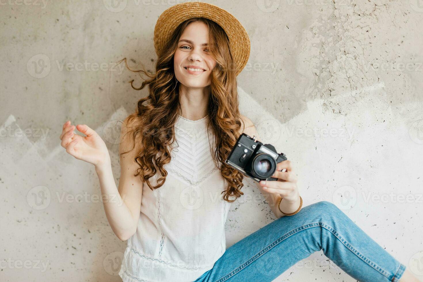 young pretty smiling happy woman in straw hat holding vintage photo camera, long curly hair