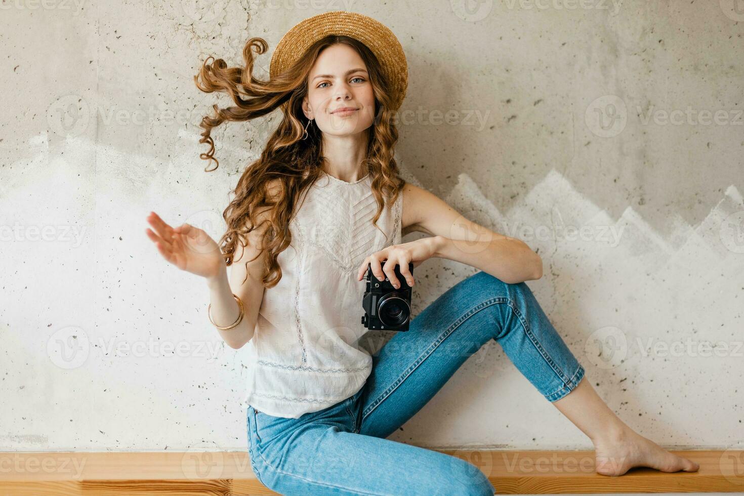 young pretty smiling happy woman in straw hat holding vintage photo camera, long curly hair