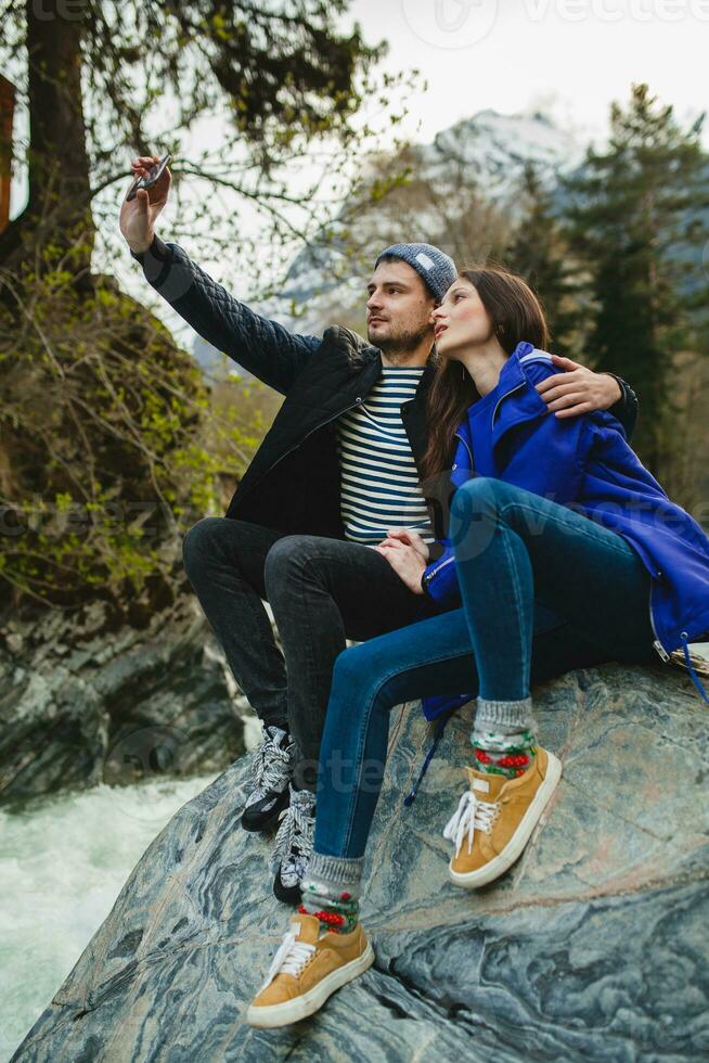 young hipster couple in love on winter vacation in mountains photo